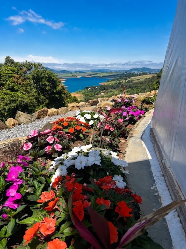 Jardim florido com vista panorâmica da Represa Jaguari e das montanhas